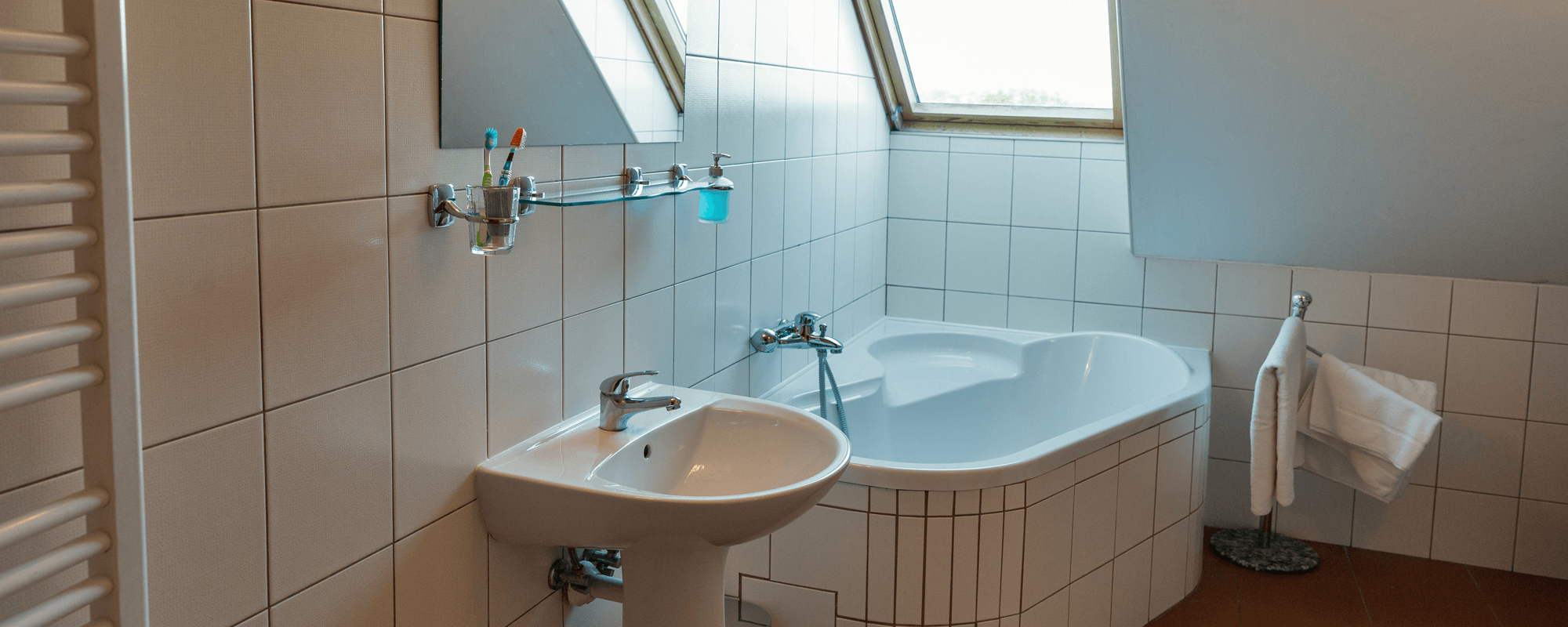 petite salle de bain avec lucarne sur la baignoire